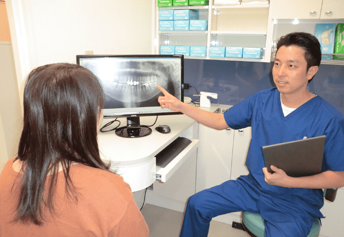セブンデンタルクリニック院内写真｜患者様へ説明する吉川院長